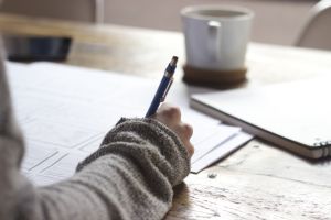 Image of a person writing with a pen.