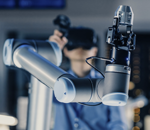 A student manipulates a robot arm. 