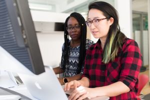 Image shows two people working at a computer together