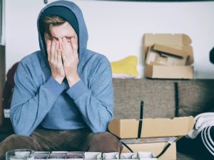 A student holds their hands over their face in an expression of frustration 