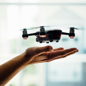 image of a drone above a person's hand